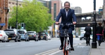 中国的共享单车来到英国 front view of a man riding a mobike in manchester