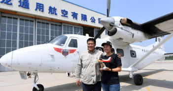 中国夫妇驾国产飞机完成环球飞行 chinese couple posing for a photo next to an airplane