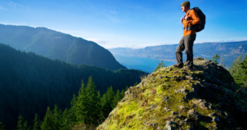 英国旅行家成功游历201国:全程不曾乘坐飞机 British man who visited 201 countries stands on rock overlooking scenery