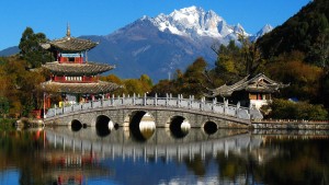 a picturesque view of bridge and mountains in lijiang