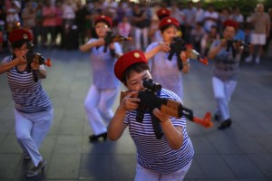 chinese dancing aunties pose with toy guns and military uniform