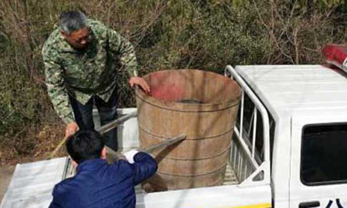 农妇被巫师装进木桶蒸烤身亡 two men loading a barrel onto a police truck