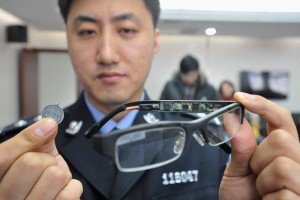 a police officer holds glasses with device confiscated during gaokao
