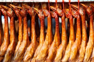 roasted ducks hanging on a street shop