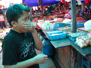 child closes his nose at stinky tofu street stall