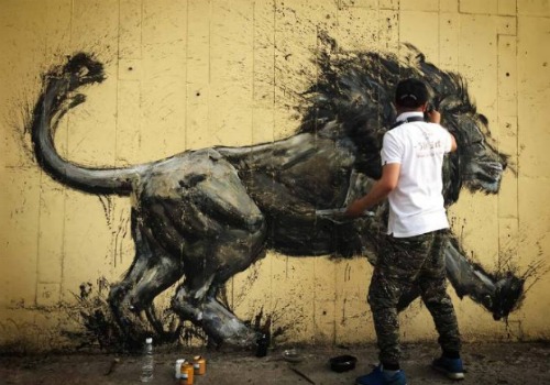 中国“班克斯”把涂鸦艺术带向中国城市 a man spray painting a lion an a wall in china