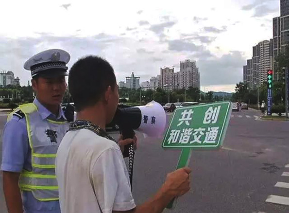 中国一男子马路上大喊“我再也不闯红灯了” back view of a man holding a microphone and a sign in china