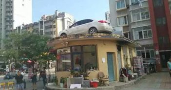 物业用吊车将堵门汽车吊到房顶 car on a building roof in china