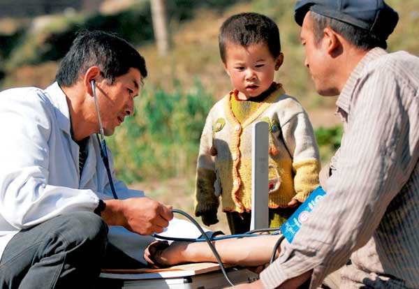 智能医疗提升中国农村医疗水平 village doctor taking blood pressure in china
