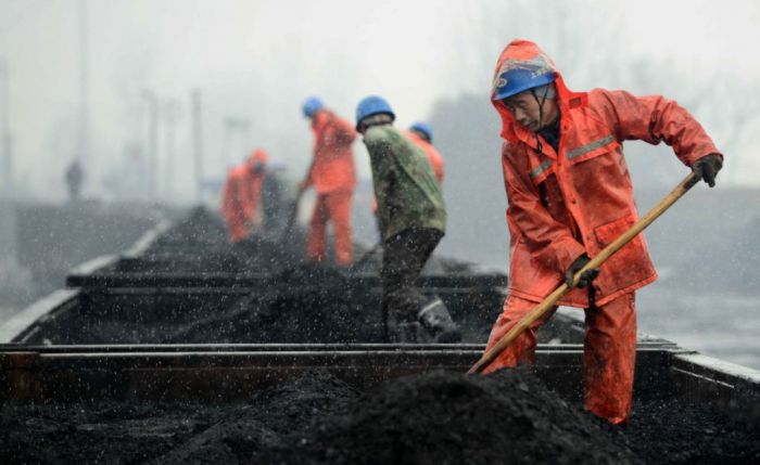 中国将全面改善技术工人福利待遇 workers loading coal onto railcars in china