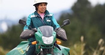 乡村女邮递员送包裹13年 front view of woman on bike in china