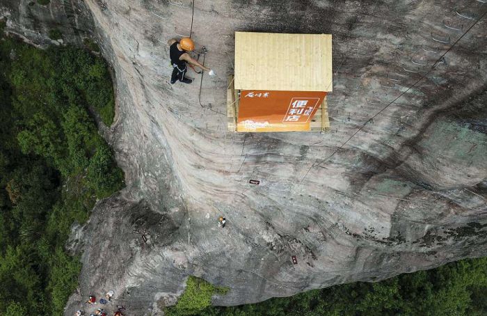 悬崖上的小店 top view of mountain climber and shop on cliff face in china