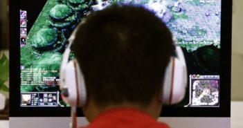 学校和家长应该不让学生沉迷网络 back view of boy's head in front of a computer