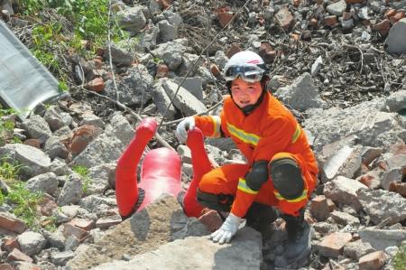少年地震英雄成消防员 top view of a young rescue worker crouching on rubble after an earthquake in sichuan