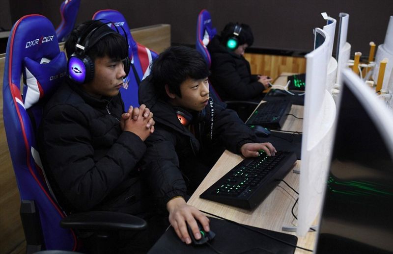 调查:五分之一中国青少年网络上瘾 side view of two teens playing computer games in china