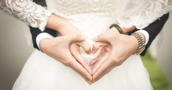 中国结婚和生育人口持续下降 middle view of groom standing behind bride and holding hands