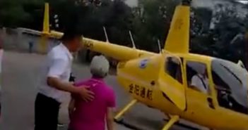 80岁老人坐直升机庆祝生日 back view of pilot walking elderly woman to helicopter in china