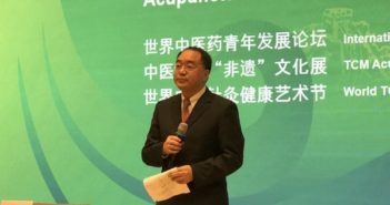 中医药针灸活动在剑桥大学举办 man giving talk at acupuncture event in uk
