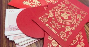 10岁男孩用压岁钱投资爸爸的公司 red packet with RMB on a table