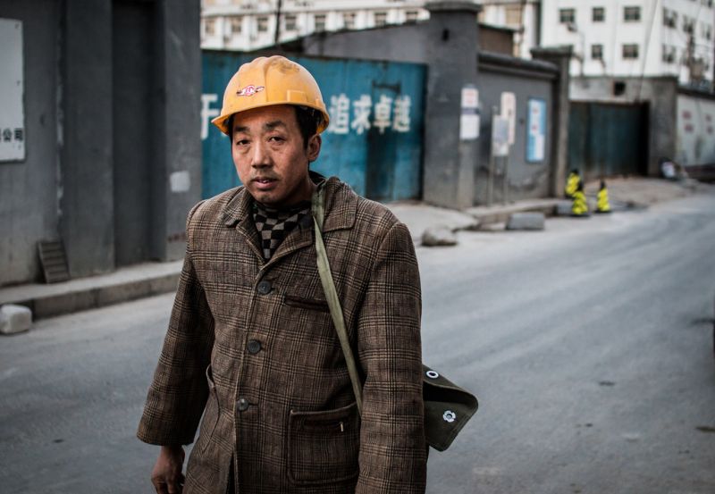 2018年中国农村1386万人脱贫 man in hard hat walking down street