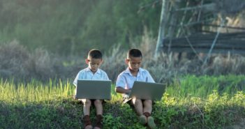 中国网民达8.29亿 two young boys sitting outside in countryside on computers