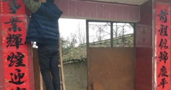 大学生寒假作业是做家务 man on ladder putting up CNY decorations in china