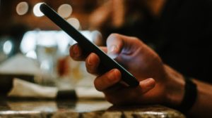 online slang: hand typing on smart phone