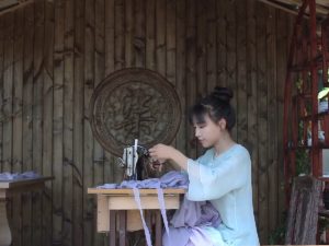 Chinese Influencers: Chinese influencers Li Ziqi sewing at a table