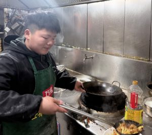 Young Cooking Pro Spends Free Time in Parent's Restaurant Kitchen